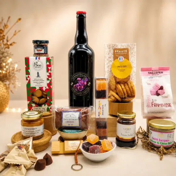 Composition artisanale présentée avec une bouteille de vin blanc, biscuits apéritifs, tartinables, pain d'épices, pâtes de fruits et spécialités artisanales dans une ambiance festive.