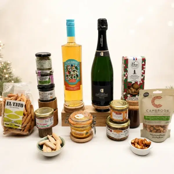 Photo d’un coffret gastronomique premium composé de spécialités salées et de boissons festives, avec champagne, apéritif aromatisé, foie gras, terrines, tartinables, biscuits apéritifs et fruits secs, présentés sur fond clair dans une ambiance élégante de fêtes.