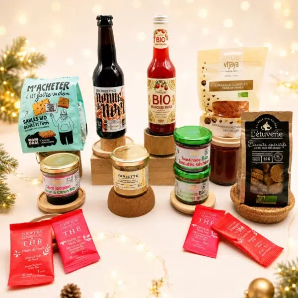 Coffret gourmand de Noël composé de produits bio et artisanaux : biscuits apéritifs, tartinades, bière rousse, boisson pétillante, orangettes confites et thé de Noël, présenté dans une ambiance festive, lumineuse et chaleureuse.