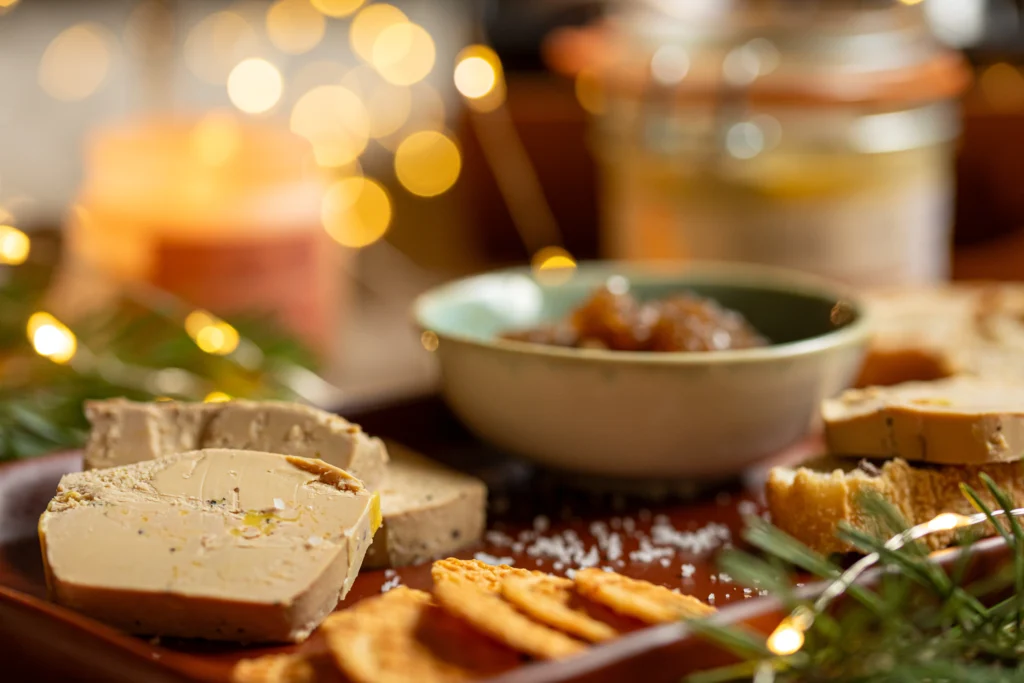 Dégustation festive de foie gras, biscuits salés et chutney dans une ambiance de Noël.